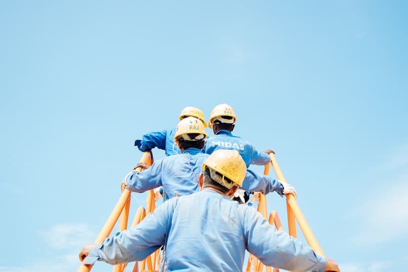 Construction crew climbing a ladder